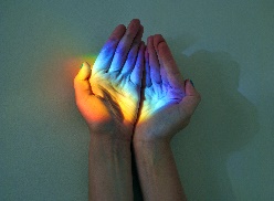 Hands catching rainbow light